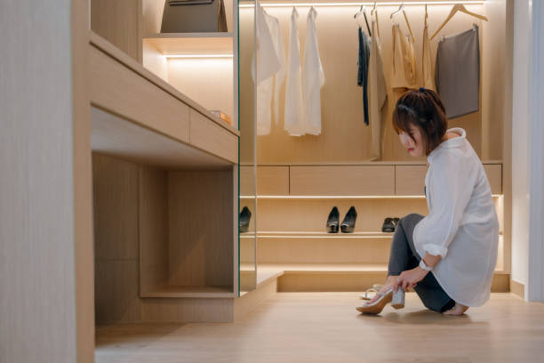 mujer asiática feliz probándose los zapatos en el vestidor de su casa - placard women holding standing fotografías e imágenes de stock