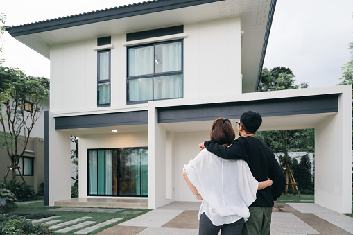 Happy Asian Couple Proudly Embracing Their New Home