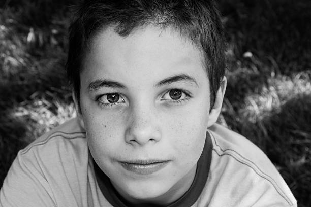 istock Boy smiling at camera in the park on sunny day 181584887