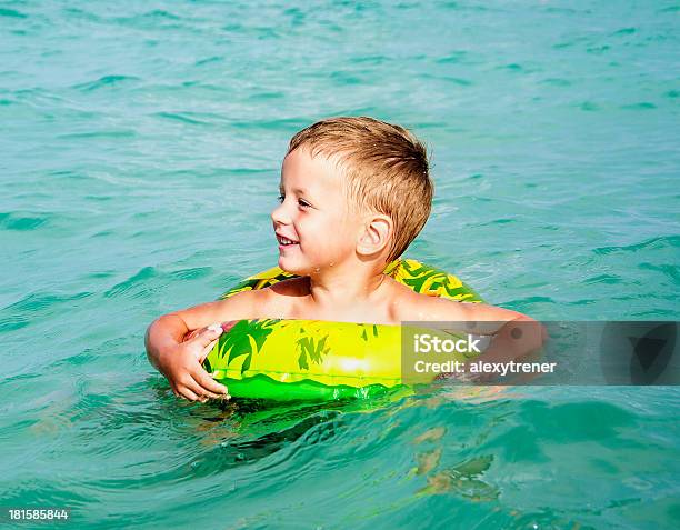 Счастливый Мальчик Наслаждаясь Плавательный В Море С Резиновым Кольцом — стоковые фотографии и другие картинки Веселье