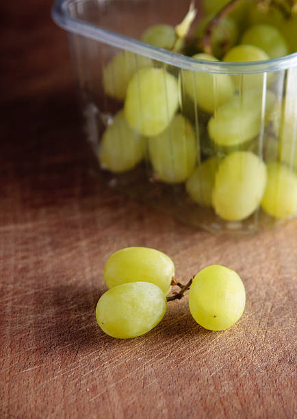 White grapes A bunch of fresh white grapes on a wooden board punnet of grapes stock pictures, royalty-free photos & images