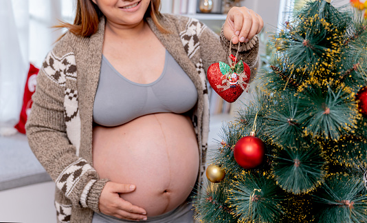 Asian pregnant woman stay alone at home. Christmas party and decoration. Family lifestyle on holiday.