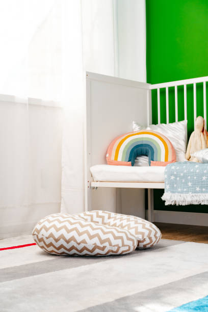 istock Kid's room interior with comfortable bed and rainbow pillow 1815936301