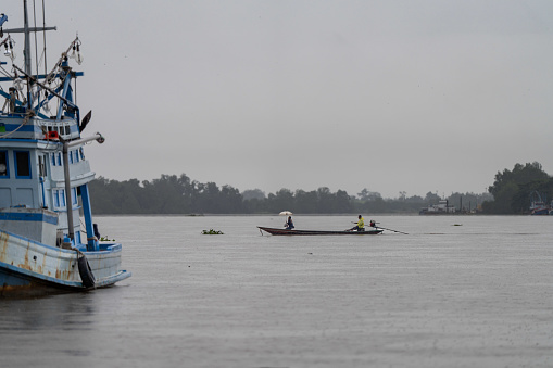 People cross the Tapi River in a longtail boat during heavy rainfall in Surat Thani, Thailand on November 27, 2023. Heavy rain and flooding take place in Surat Thani, Thailand, a tropical area increasingly affected by climate change during the south's rainy season.