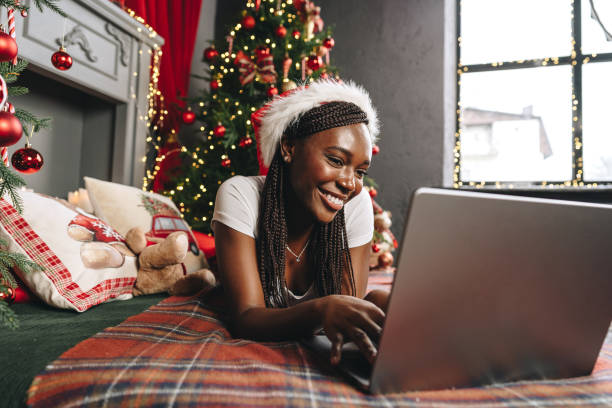 istock Young African woman on bed using laptop on Christmas eve 1815970113