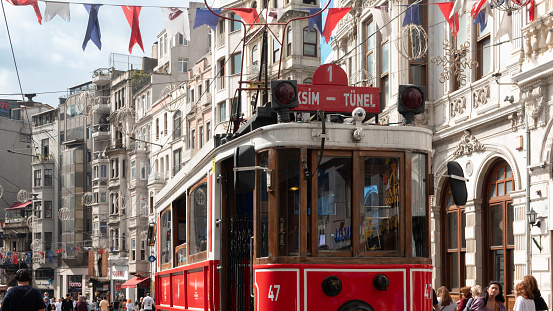 Istanbul-Turkey: Sep.20, 2023: Tourists and local people travelling by historical red tramway. Nostalgic tram in Taksim Istiklal Street. Taksim one of the most popular tourist destinations in Istanbul