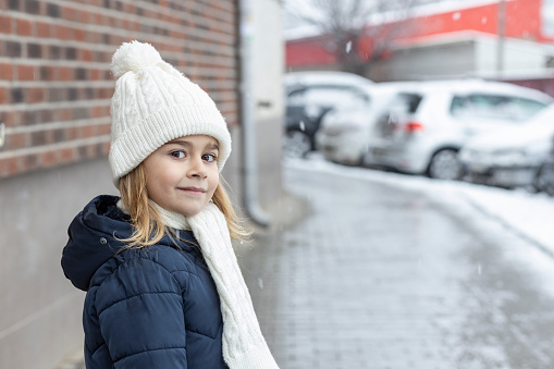 Cute child wearing a hat and a scarf outside