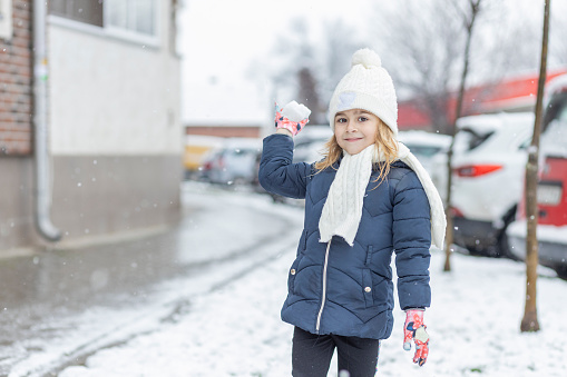 A happy young girl holding a snowball