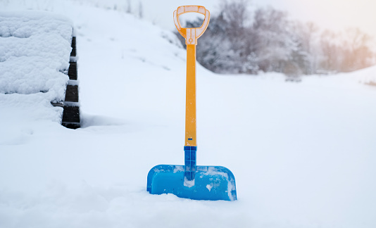 Shovel sticking out in a large snowdrift, close-up