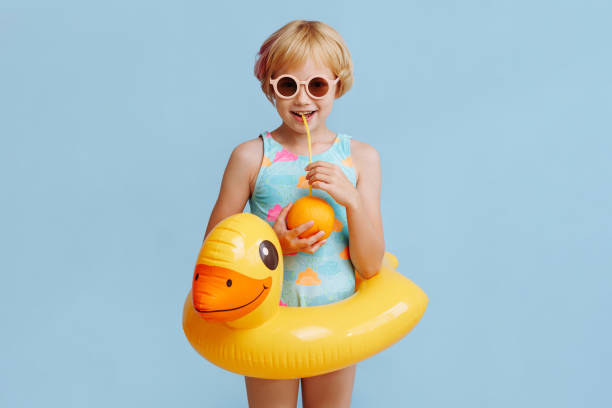 istock Child with inflatable duck ring on blue background with copy space. 1815995222