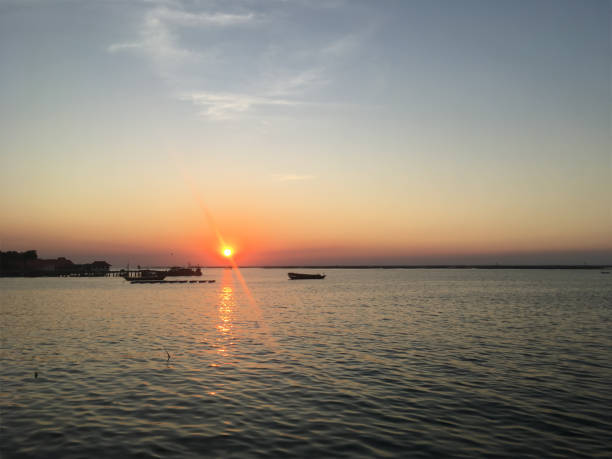 istock The sun was setting over the sea in the evening, casting a reddish-orange glow on the surface of the water. 1816003160