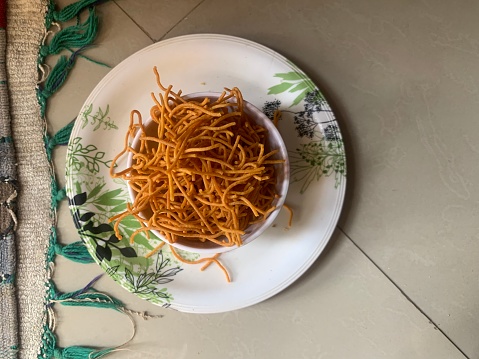 Indian popular snacks called Bhujia Sev or shev in bowl. Pepper Sev consisting of small pieces of crunchy noodles made from chickpea flour. Diwali festival snacks.