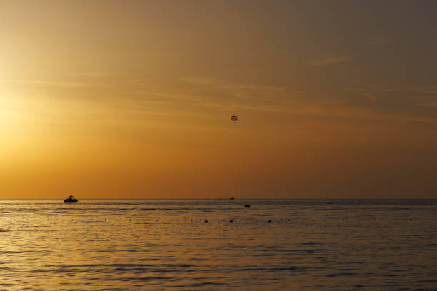 Sunset sea with parachute in the sky