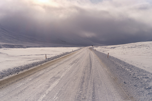 View of the empty road covered with snow and ice during winter day in Iceland. Photographed in medium format.
