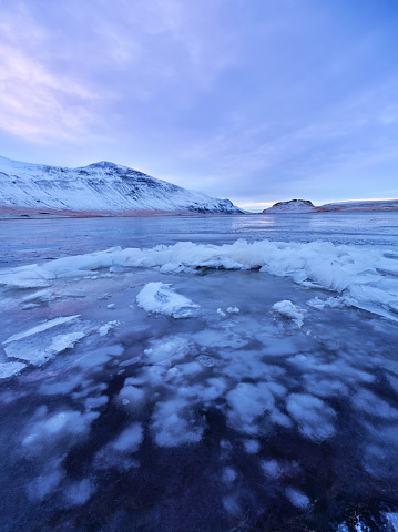 Frozen lagoon with snowcapped mountain range in Iceland. Photographed in medium format.