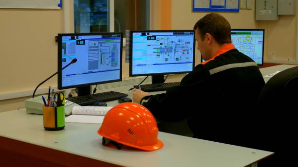 istock Focused worker in industrial setting scrutinizes equipment performance on monitor. Worker operates control panel, ensuring optimal functionality. Video captures worker maintaining efficiency. 1816041642