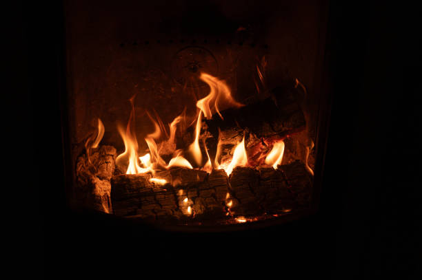 open flames and firewood in fireplace behind glass Kumla Sweden November 24 2023