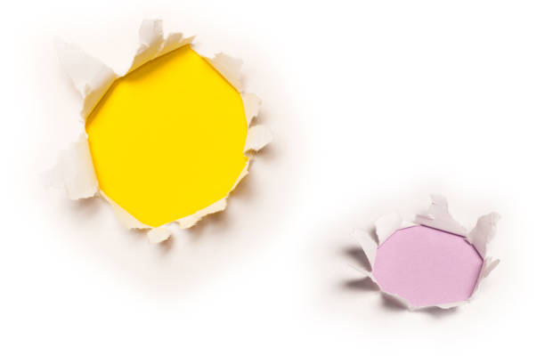 istock A hole in a white paper on a yellow background. 1816110143