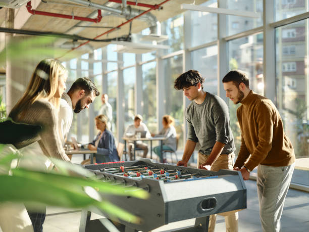 istock Young colleagues playing table soccer during a break at casual office. 1816111282