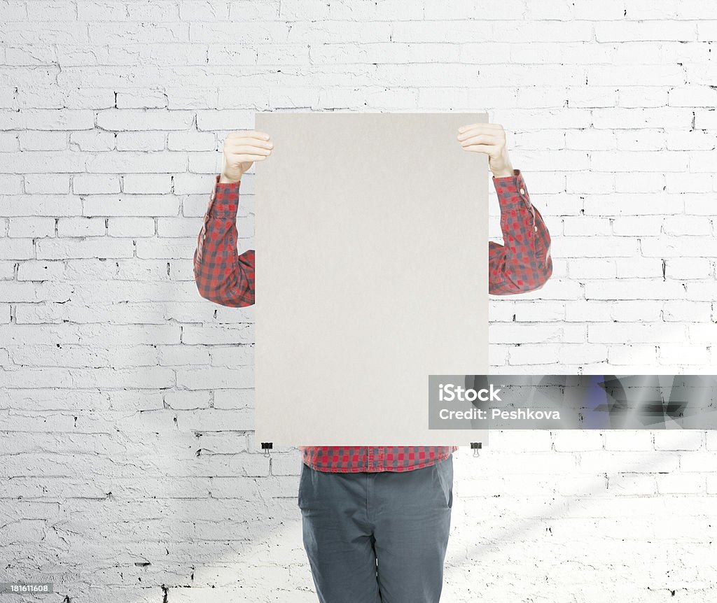 man holding poster man holding blank poster on brick background Adult Stock Photo