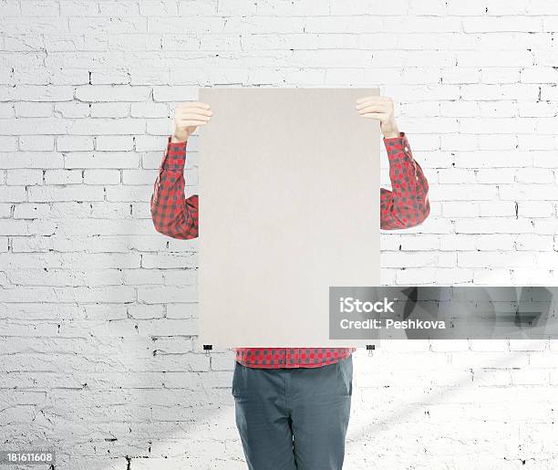 Man Holding Poster Stock Photo - Download Image Now - Adult, Brick, Brick Wall