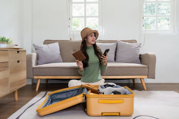 mulher feliz usando o smartphone reservando férias na agência de viagens ou fazendo reserva de hotel on-line - national cash register - fotografias e filmes do acervo