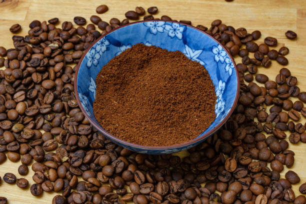 A bowl full of altered coffee surrounded by roasted coffee beans