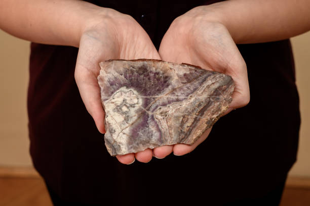 istock Purple stone, quartz, amethyst, cut cross-section, held in hands 1816142737