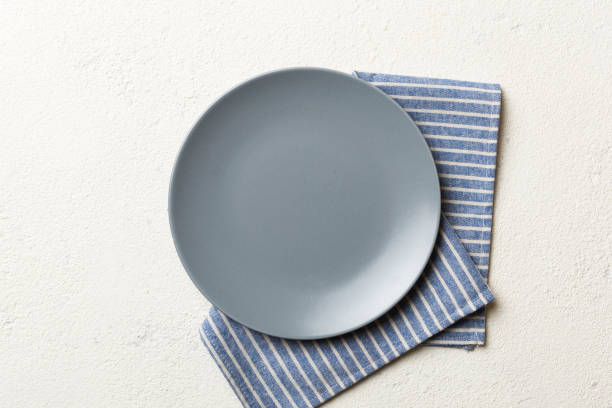 istock Top view on colored background empty round gray plate on tablecloth for food. Empty dish on napkin with space for your design 1816157001