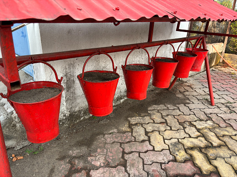 Red fire buckets filled with sand to protect in case of fire Fire Safety, Sand Filled Bucket use to Prevent Fire at petrol pump.