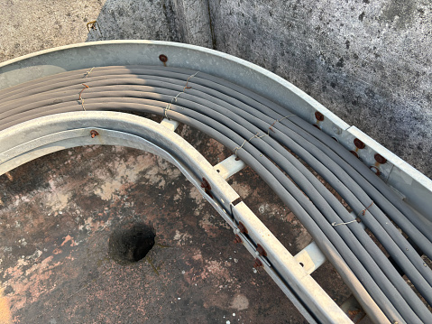 Closeup of old black electric cables in a cable tray