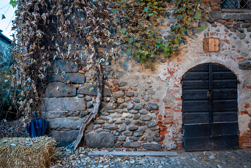 Italy, Ricetto di Candelo. Panorama of a medieval village. History and culture of Italy and Europe. Wooden door isolated in foreground.