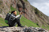 Hiker taking photos with smartphone in nature
