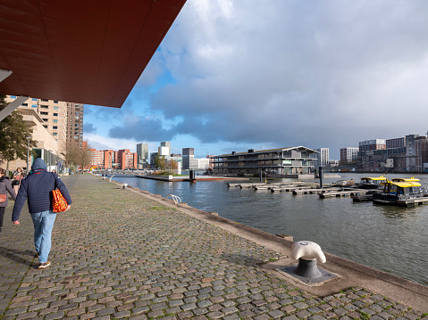 rotterdam, netherlands, 25 november 2023: people walk near rijnhaven on kop van zuid in dutch city of rotterdam