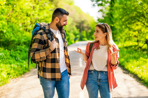 Happy couple hiking in nature on sunny day. Couple enjoying their vacation.