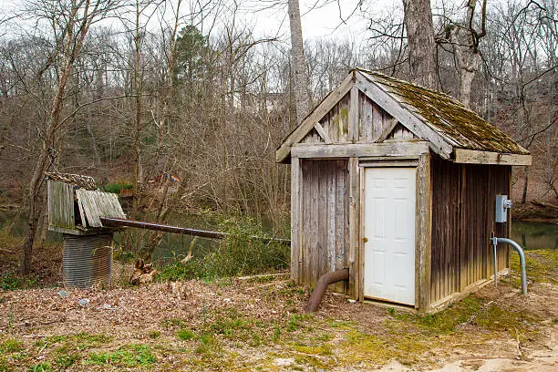 An old wood shed or pump house near a winter river