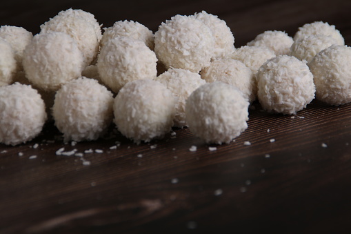 In this sweet photo, a set of homemade coconut candy balls showcases their round, tempting charm against a clean dark backdrop. These tasty confections promise a delightful dessert or snack, combining the allure of sweetness with homemade goodness. delicious, gourmet, sugar, fresh, group, beauty, assortment