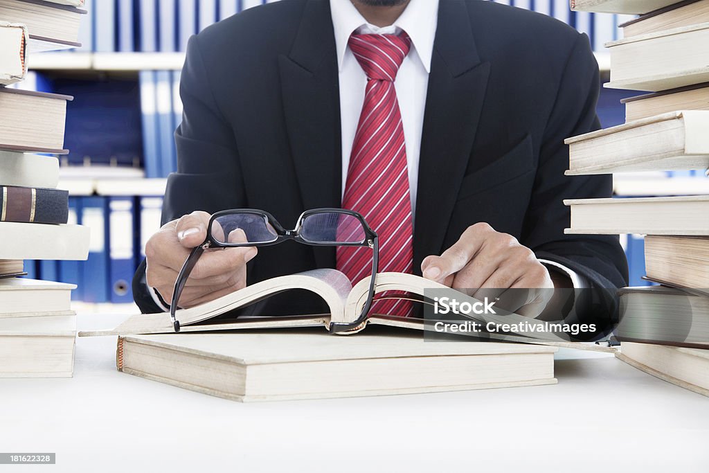 Uomo d'affari di leggere senza occhiali nella Libreria - Foto stock royalty-free di 20-24 anni