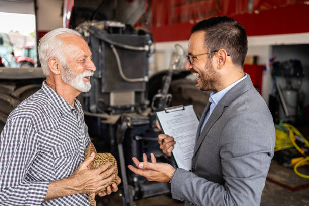 istock Dealer and farmer in tractor workshop talking about service and maintenance. 1816228979