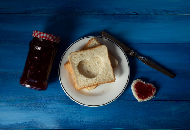Heart of double breads and strawberry jam on square breads