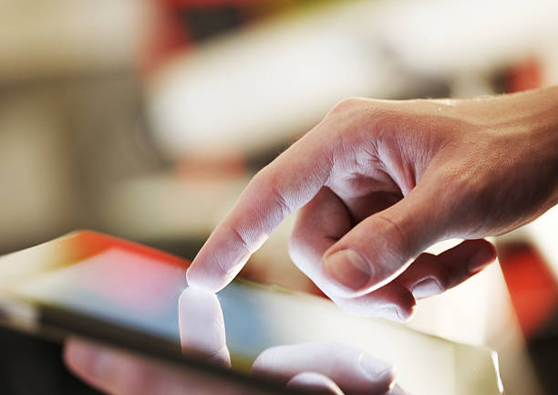 istock Close up of man's hand poring on tablet device 181623921