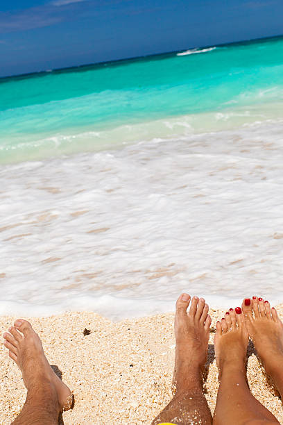 istock Male and female legs on tropical beach 181624253