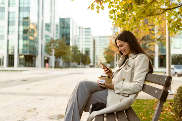 Businesswoman on lunch break in front of the office stock photo