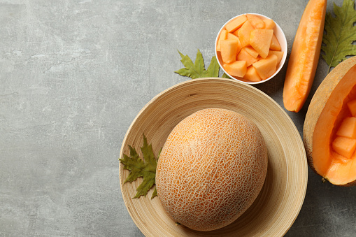Concept of fresh food with melon on gray textured table