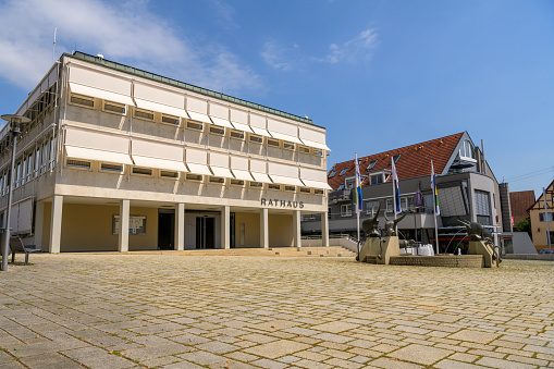 Dettingen Teck, Germany, August 23 2023: City hall with city hall fountain on town square on sunny day