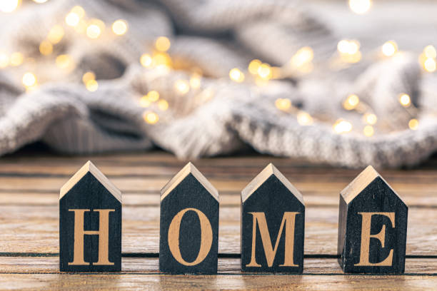 istock Cozy background with decorative word Home on a blurred background with garland. 1816290003