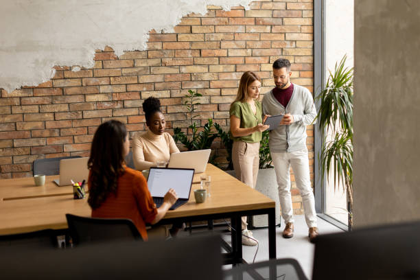 istock Young multiethnic startup team working by the brick wall in the industrial style office 1816293311