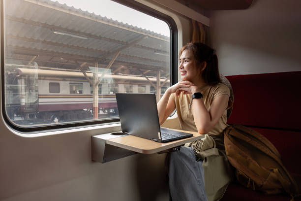 istock Young Asian woman uses a laptop while sitting on a train. 1816298216