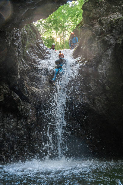 キャニオニングアドベンチャーでラッペルロープで滝を下る人 - 30063 ストックフォトと画像