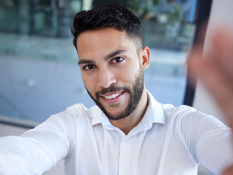 Businessman, portrait smile and selfie at the office for social media, profile or status update. Happy man employee face smiling in happiness for photo, career or new job startup at the workplace
